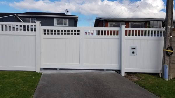Epsom PVC privacy fence with trellis top, 1830mm high x 2400mm wide panel. Available in white or with grey insert panels. Front view setting, classic design for New Zealand homes.