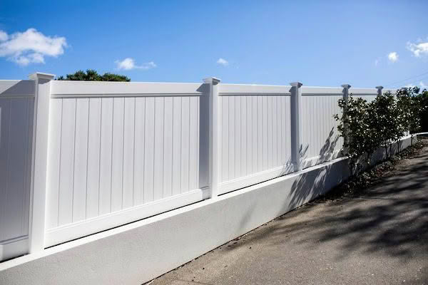 Metro PVC full privacy fence in white or grey, 1830mm high x 2400mm wide panel, durable and low-maintenance. Shown in a driveway installation, suitable for New Zealand conditions, can be stepped or sloped.