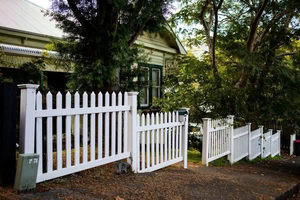 Villa PVC picket fence, 1200mm high x 2400mm wide panels. Provides a classic look with pickets centred through top and bottom rails, ensuring the same style on both sides. Shown in garden style setting, low-maintenance and available with matching gates.